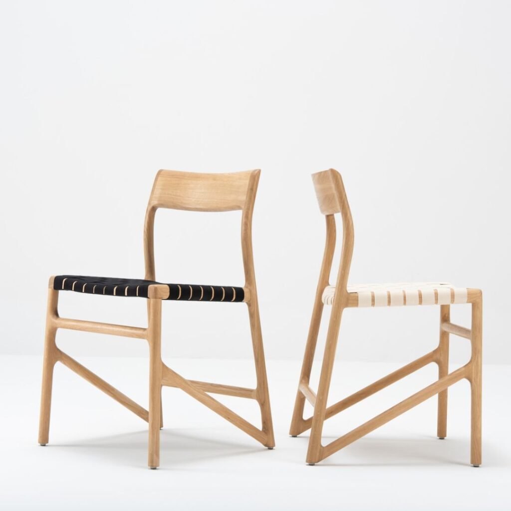 Deux chaises Marie en chêne massif, l’une avec une assise en coton tressé noir et l’autre en blanc, illustrant les différentes options de finition disponibles.