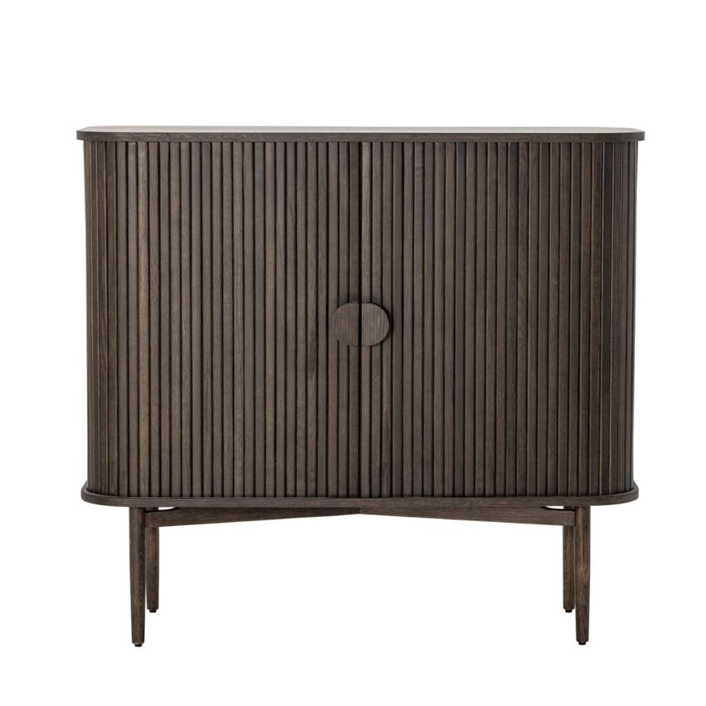 Buffet en bois foncé avec des lattes verticales et un bouton de porte circulaire, vu de face. Son design moderne et minimaliste repose sur des pieds fins pour une touche élégante.
